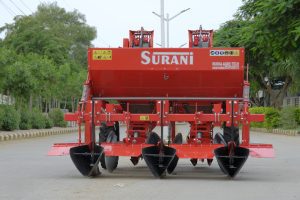 Potato planter machine attached to tractor for automatic potato sowing in farm field